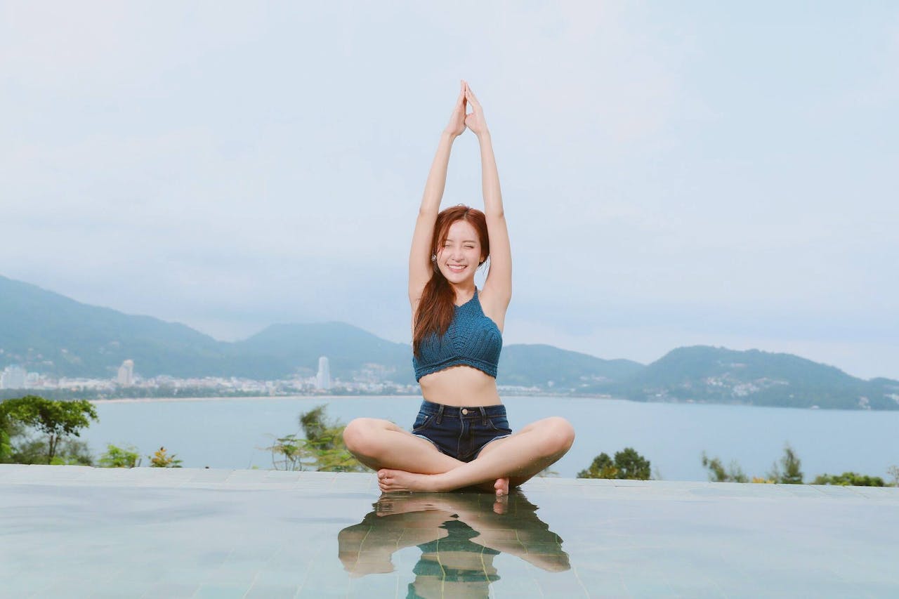 gallery-05 Young woman doing yoga by a scenic waterfront, enjoying a serene landscape.