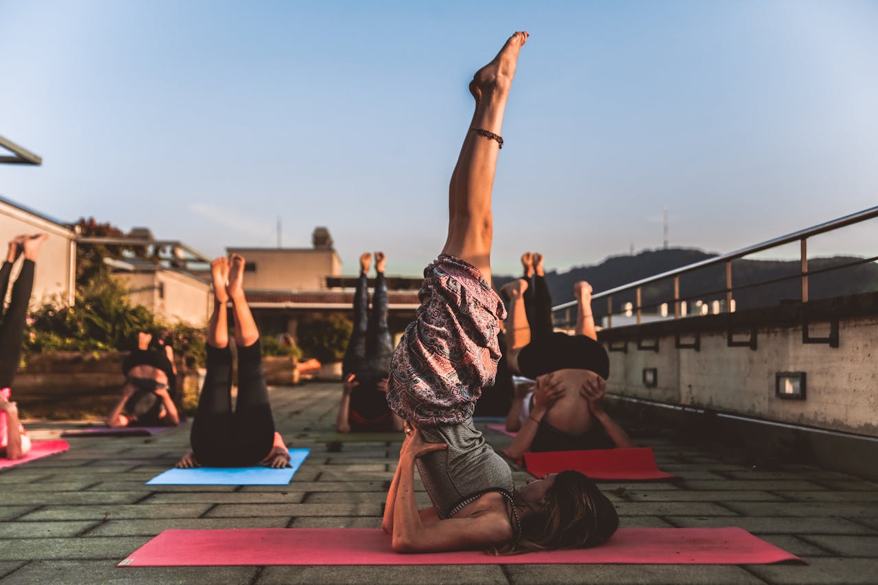 gallery-04 People practicing yoga on mats outdoors during sunset, focusing on wellness.