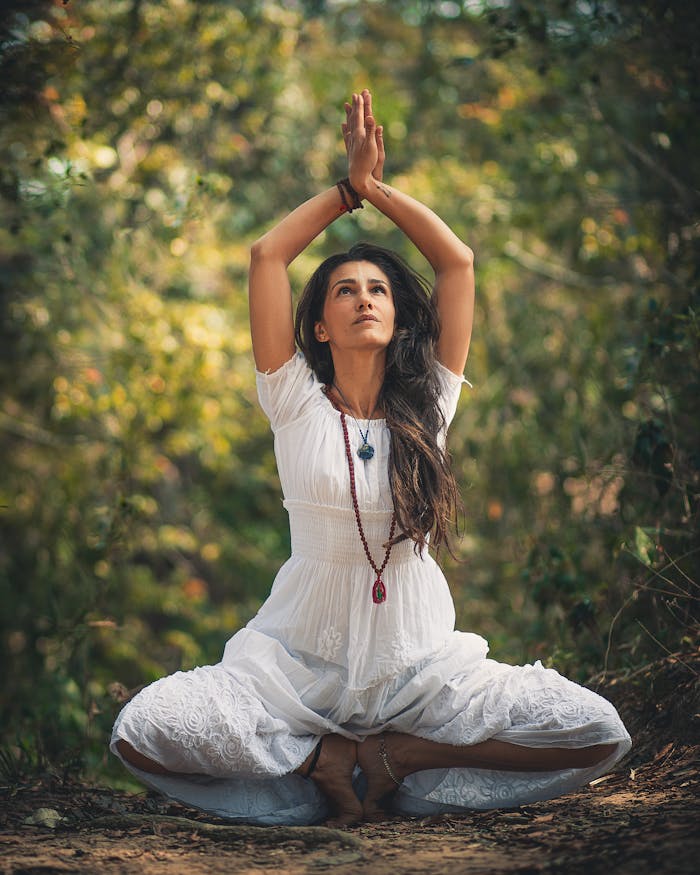 gallery-01 A woman meditating outdoors in a forest setting, embracing tranquility.